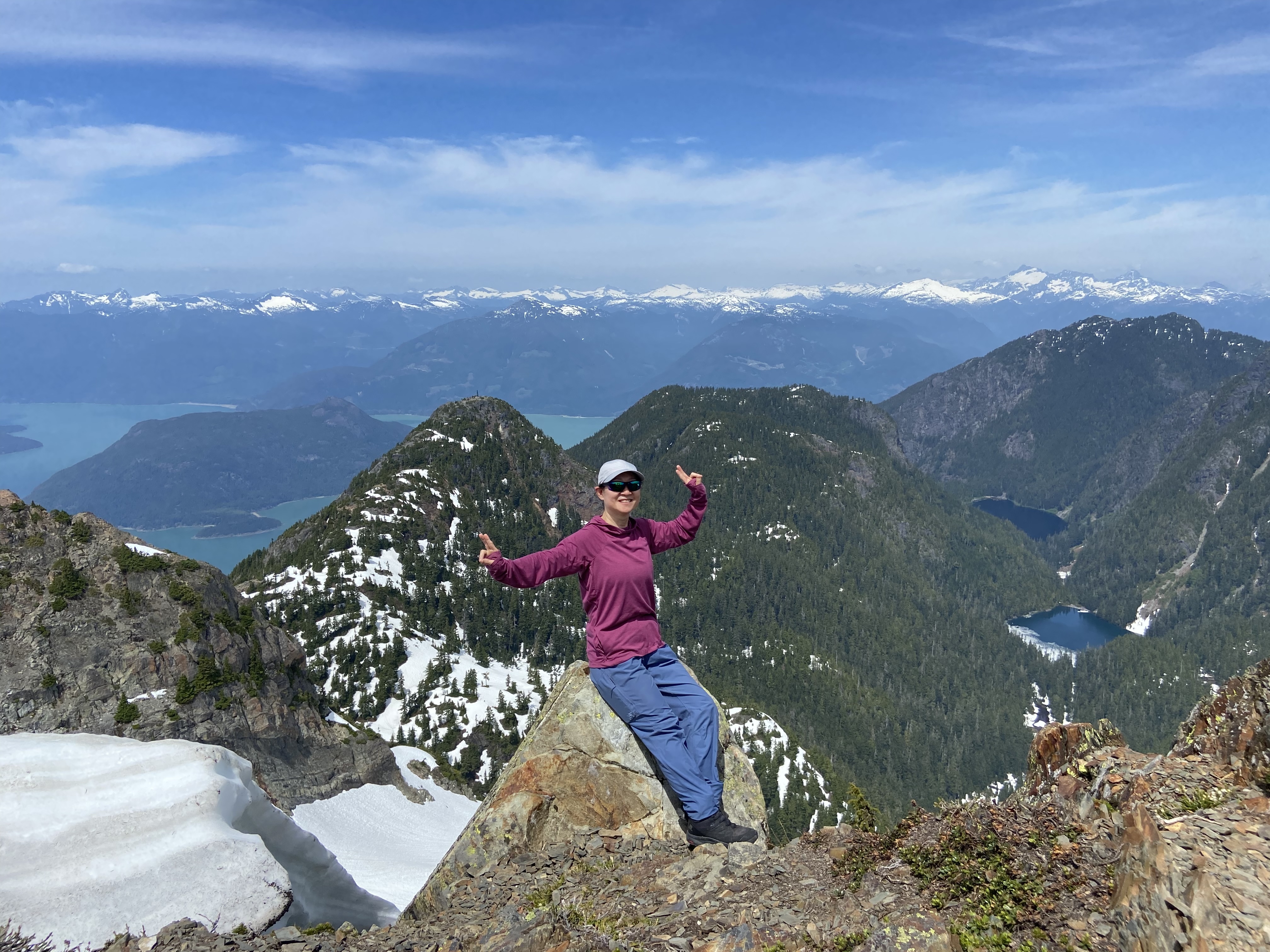Helen proudly posing on a rock surface at the summit