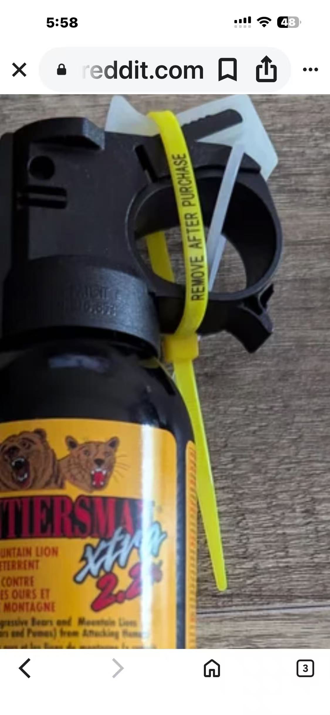 Bear spray canister showing safety clip and zip ties