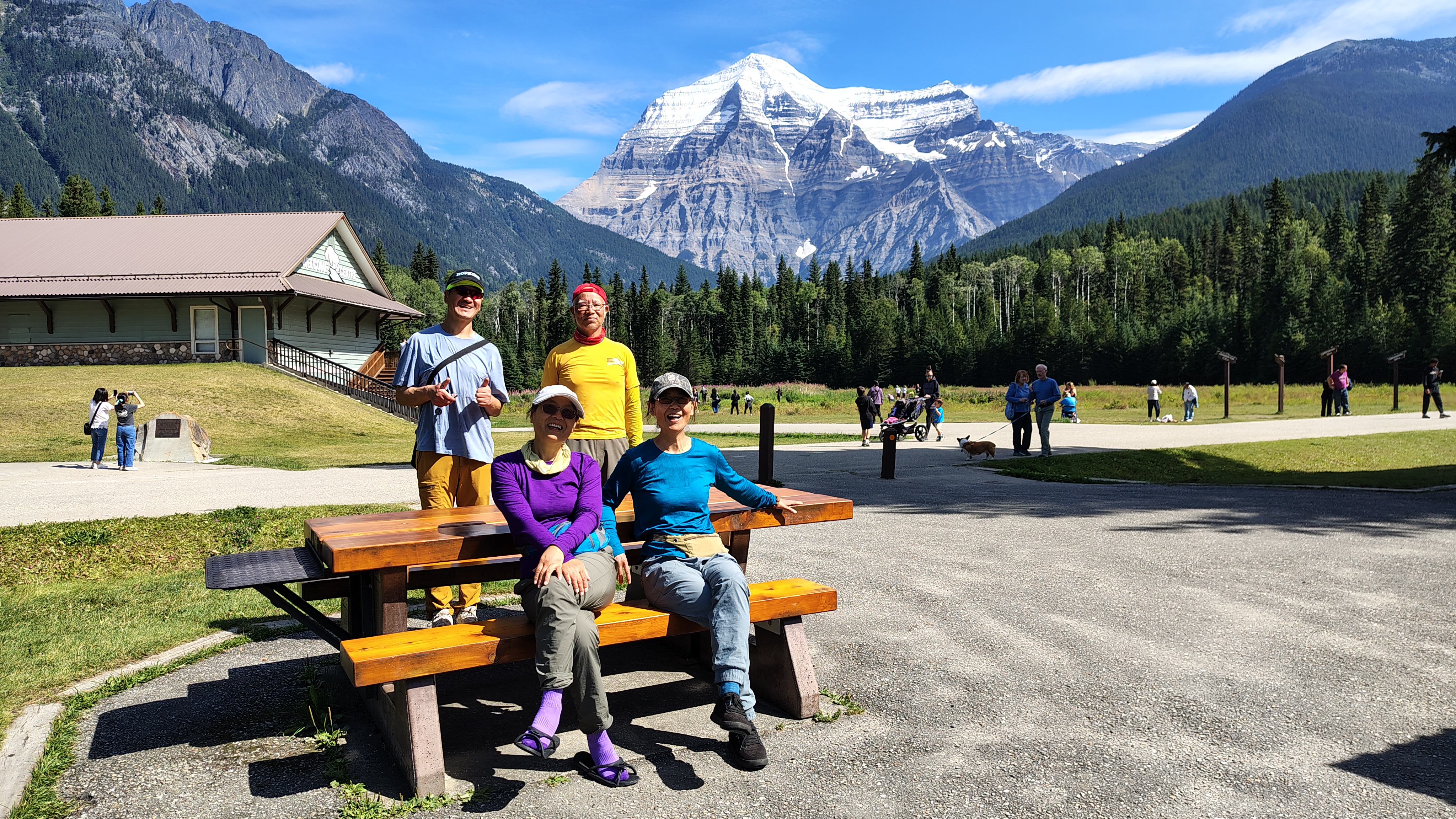 Lily and Huixin sitting on bench, Patrick and Brian behind, Mt Robson in back